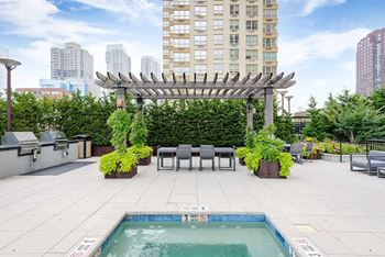 A pool with a 3 feet deep sign is surrounded by a patio with chairs and a pergola.